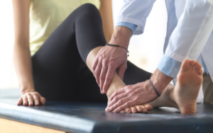 A physio assessing a persons ankle following ankle sprain